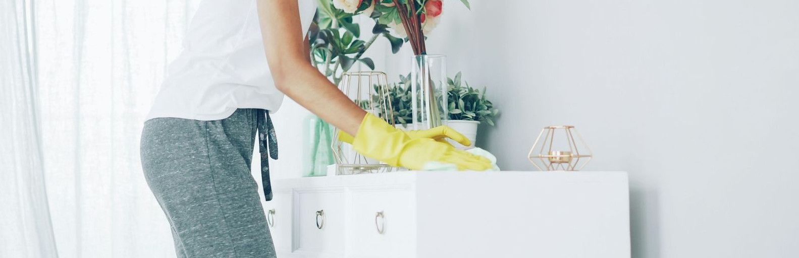 Woman with headphones cleaning a shelf